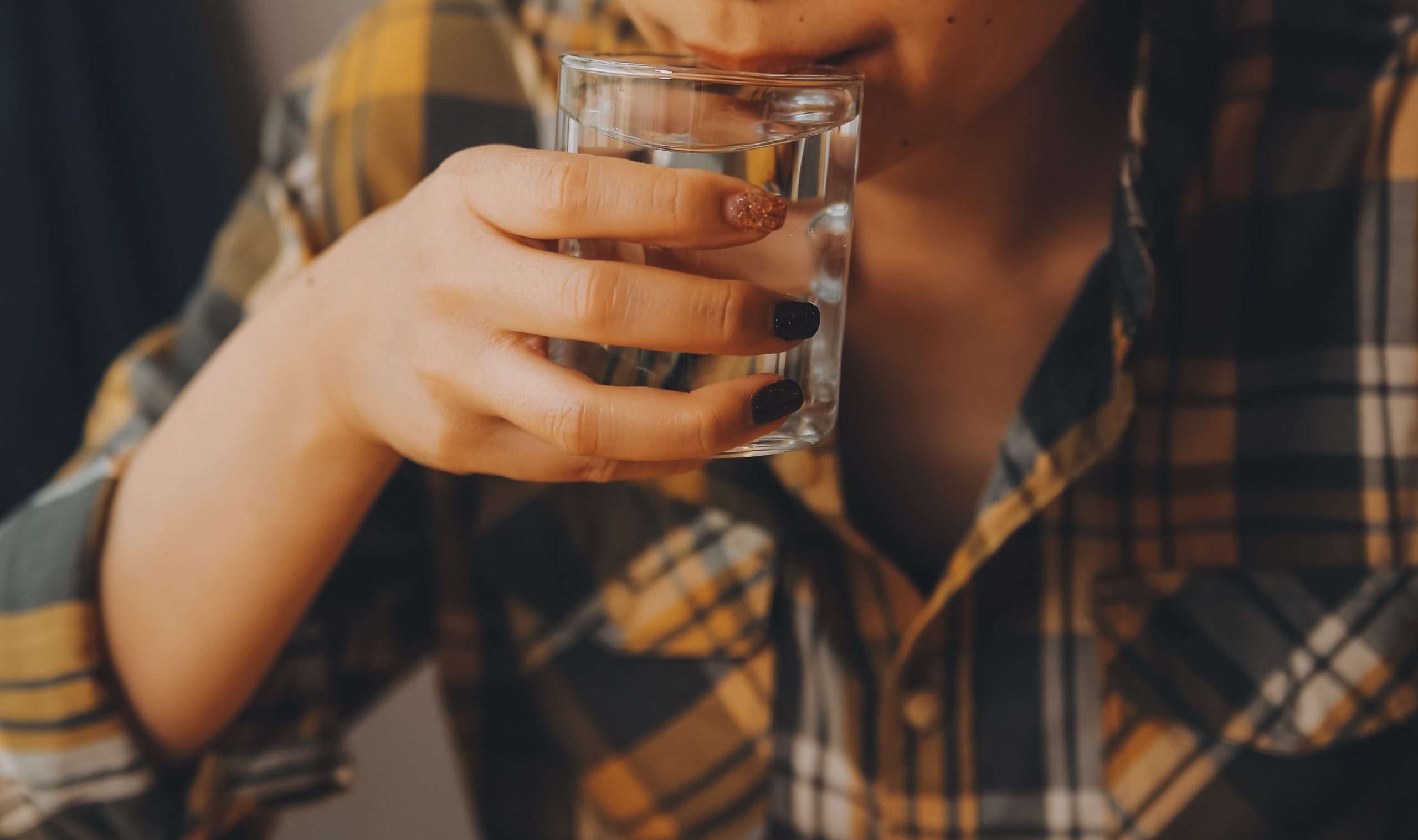 A young woman holding glass of water